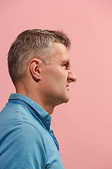 Image showing The young emotional angry man screaming on pink studio background