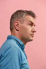 Image showing Suspiciont. Doubtful pensive man with thoughtful expression making choice against pink background