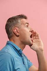 Image showing Isolated on pink young casual man shouting at studio