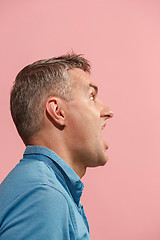 Image showing The young emotional angry man screaming on pink studio background