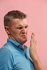 Image showing Let me think. Doubtful pensive man with thoughtful expression making choice against pink background