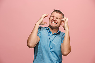 Image showing The young emotional angry man screaming on pink studio background