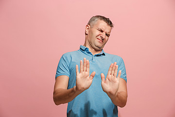 Image showing Let me think. Doubtful pensive man with thoughtful expression making choice against pink background