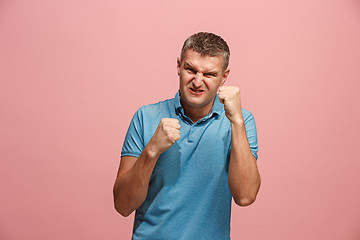 Image showing The young emotional angry man screaming on pink studio background