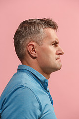 Image showing Suspiciont. Doubtful pensive man with thoughtful expression making choice against pink background