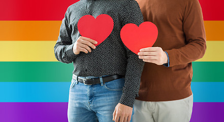 Image showing close up of happy male couple holding red hearts