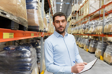 Image showing businessman with clipboard at warehouse