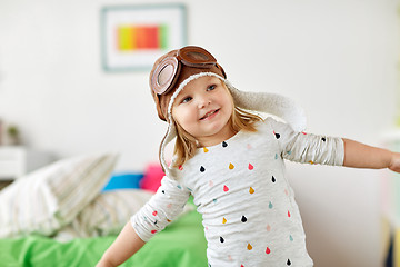 Image showing happy little girl in pilot hat playing at home