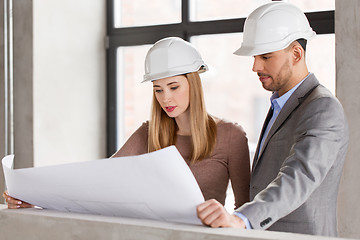 Image showing architects with blueprint and helmets at office