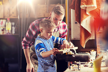 Image showing father and son with ruler measure wood at workshop