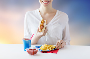 Image showing close up of woman eating hotdog and french fries