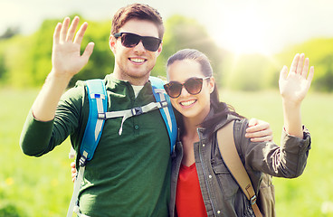 Image showing happy couple with backpacks hiking outdoors