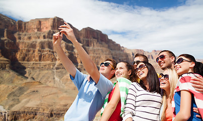 Image showing group of happy friends taking selfie by cell phone