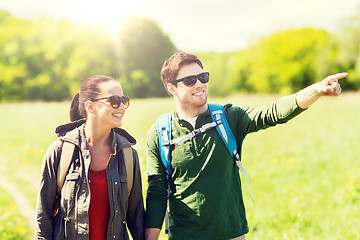 Image showing happy couple with backpacks hiking outdoors