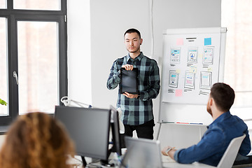 Image showing man showing tablet pc to creative team at office