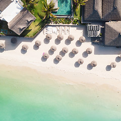 Image showing Aerial view of amazing tropical white sandy beach with palm leaves umbrellas and turquoise sea, Mauritius.