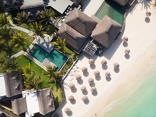 Image showing Aerial view of amazing tropical white sandy beach with palm leaves umbrellas and turquoise sea, Mauritius.