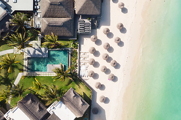 Image showing Aerial view of amazing tropical white sandy beach with palm leaves umbrellas and turquoise sea, Mauritius.