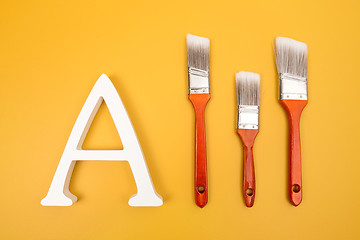 Image showing Letter A and paintbrushes on yellow background