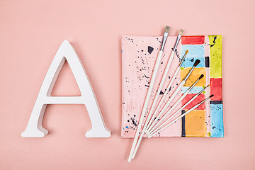 Image showing Letter A and paintbrushes on a colorful plate