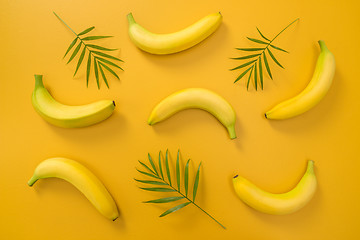 Image showing Palm leaves and bananas on yellow background