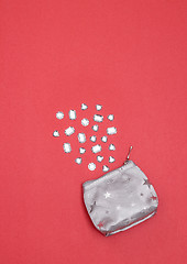 Image showing Rhinestones and silver purse on vivid pink background