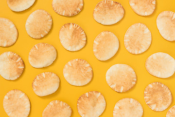 Image showing Lots of mini pita bread on yellow background