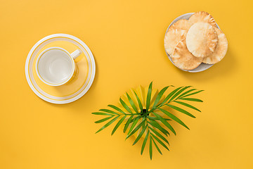 Image showing Teacup, palm leaves and and plate with pita bread