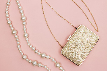 Image showing Golden purse and pearl necklace on pink background