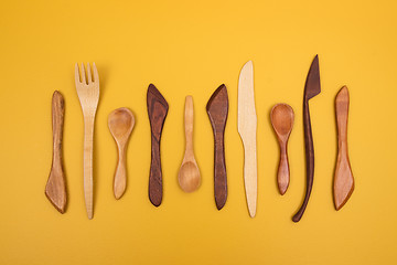 Image showing Handcrafted wooden utensils on yellow background