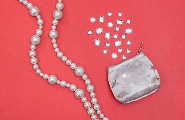 Image showing Pearl necklace and silver purse with shiny gems