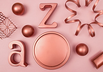 Image showing Decorative copper objects on pastel pink background