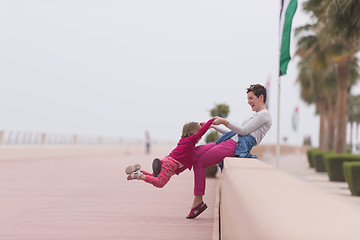 Image showing mother and cute little girl on the promenade by the sea