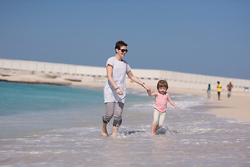 Image showing mother and daughter running on the beach