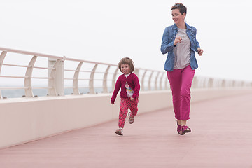 Image showing mother and cute little girl on the promenade by the sea