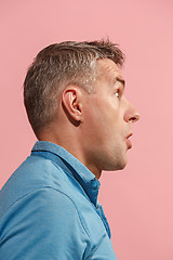 Image showing The young attractive man looking suprised isolated on pink