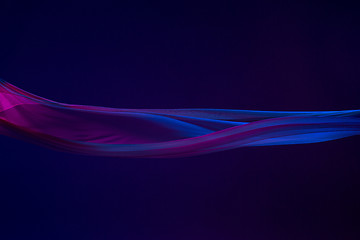 Image showing Smooth elegant transparent blue cloth separated on blue background.