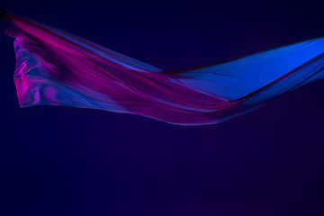 Image showing Smooth elegant transparent blue cloth separated on blue background.