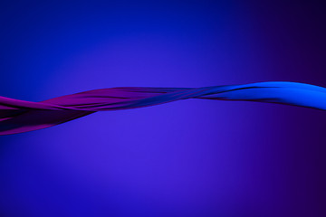 Image showing Smooth elegant transparent blue cloth separated on blue background.