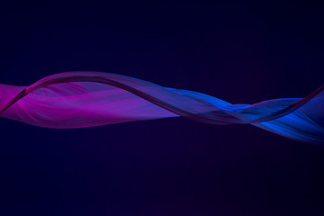 Image showing Smooth elegant transparent blue cloth separated on blue background.