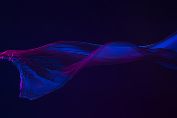 Image showing Smooth elegant transparent blue cloth separated on blue background.