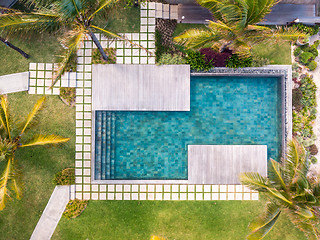 Image showing Aerial view of luxury hotel resort with swimming pool with stair and wooden deck surrounded by palm trees.