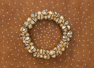 Image showing Golden jingle bells wreath on leather background