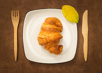 Image showing Croissant on a plate decorated with autumn leaf