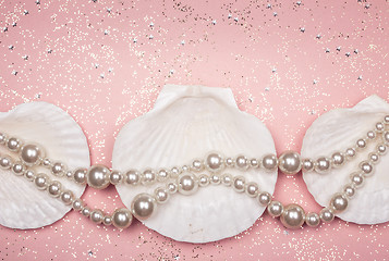 Image showing Pearl necklace and seashells on glitter pink background