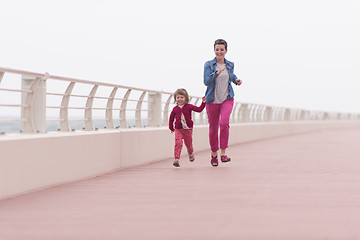 Image showing mother and cute little girl on the promenade by the sea