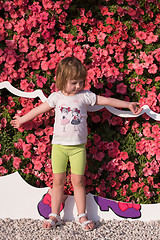 Image showing little cute girl in a flower garden
