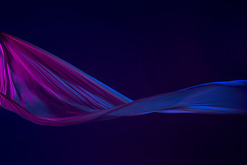 Image showing Smooth elegant transparent blue cloth separated on blue background.