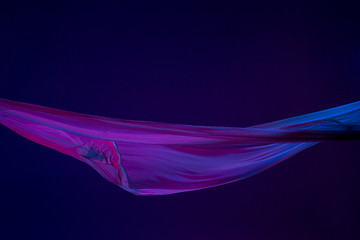 Image showing Smooth elegant transparent blue cloth separated on blue background.