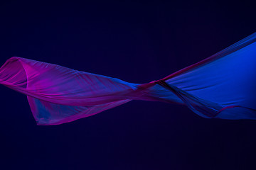 Image showing Smooth elegant transparent blue cloth separated on blue background.